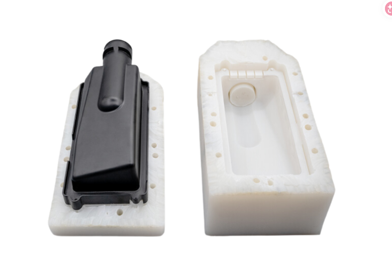 Black plastic part and its white mold, likely from CNC machining.