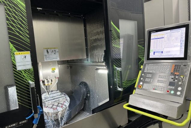 CNC milling machine with control panel displaying program code