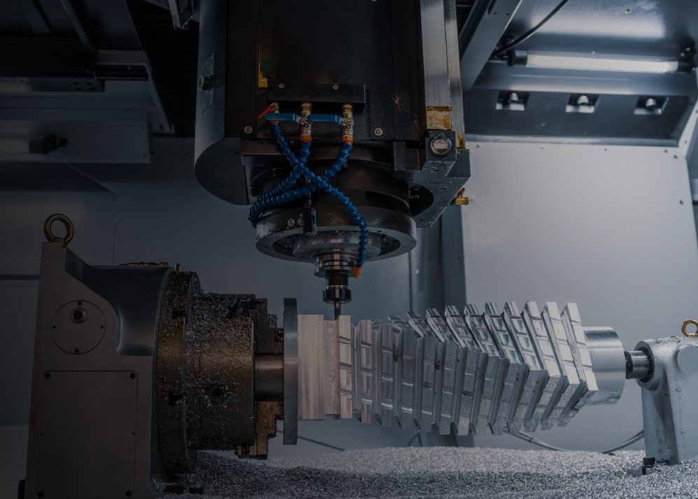 CNC machine milling a complex metal part with shavings on the floor